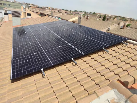 Paneles solares sobre tejado de teja con vistas al pueblo en Ejea de los Caballeros