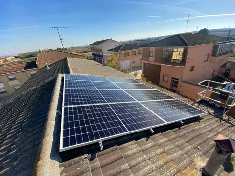 Amplia instalación de paneles solares sobre tejado con vistas al pueblo en Gallur