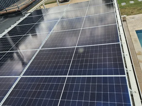 Paneles solares sobre cubierta plana junto a una piscina en Zuera