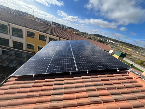 Paneles solares sobre tejado de teja con vistas a la ciudad de Burgos
