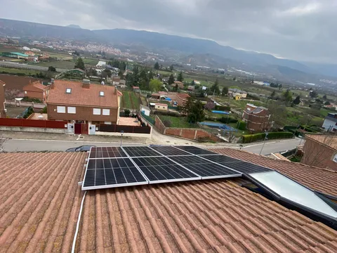 Paneles solares sobre tejado de teja con vistas al valle en Albelda de Iregua