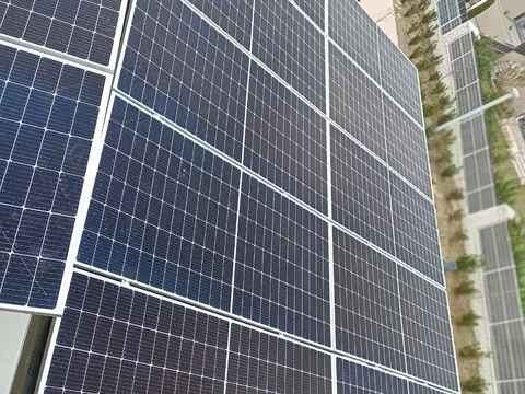 Paneles solares vistos de cerca sobre cubierta, con el barrio al fondo, en San Sebastián de los Reyes
