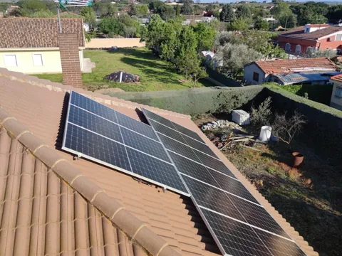 Paneles solares sobre tejado de teja con vistas al jardín y al pueblo en Valdetorres de Jarama