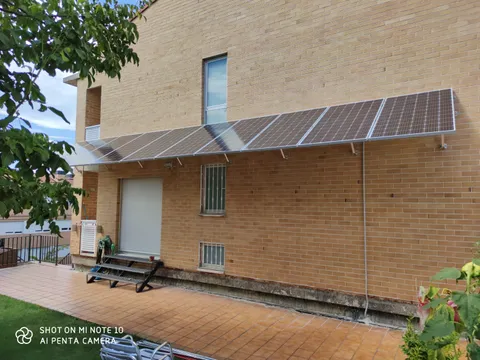 Paneles solares sobre marquesina de un patio en Noáin