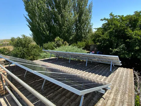 Instalación aislada de paneles solares sobre tejado de fibrocemento en una huerta de Tudela
