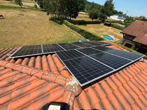 Paneles solares sobre tejado de teja con jardín y piscina en Amurrio