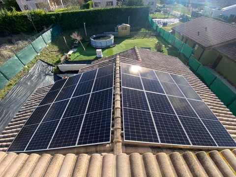Paneles solares en dos vertientes de tejado sobre un jardín en Argómaniz