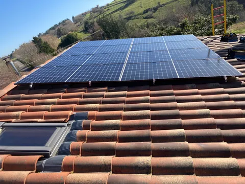 Paneles solares sobre tejado de teja con vistas al valle en Errigoiti