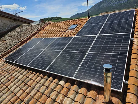 Amplia instalación de paneles solares sobre tejado de teja con vistas a la sierra en Espejo