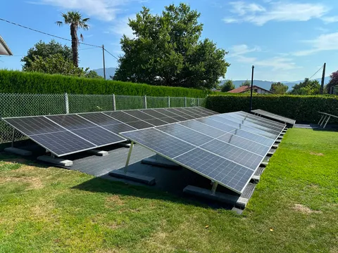 Amplia instalación de paneles solares sobre estructura en el suelo de un jardín en Gatika