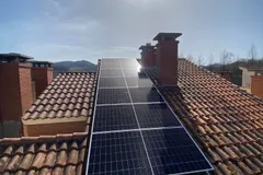 Paneles solares sobre tejado de teja entre chimeneas en Oiartzun, País Vasco