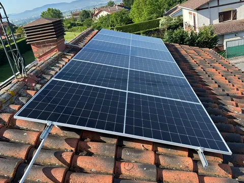 Paneles solares sobre tejado de teja con vistas al valle en Vitoria-Gasteiz