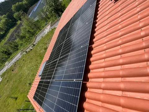 Paneles solares sobre tejado de teja con vistas al valle en Zarautz