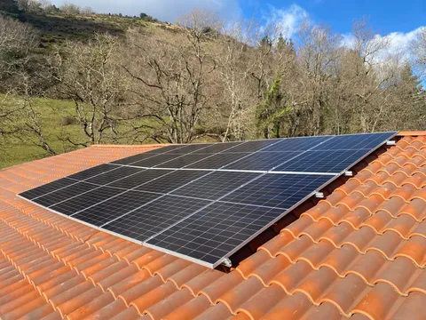 Paneles solares sobre tejado de teja con vistas a la montaña en Zerain