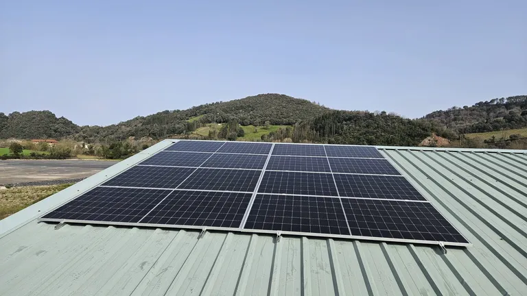 Paneles solares sobre cubierta metálica verde en una vivienda de Zumaia, País Vasco